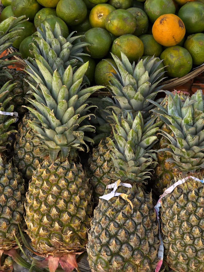 About Close-up of ripe pineapples and citrus fruits at a market in Bhopal, India.